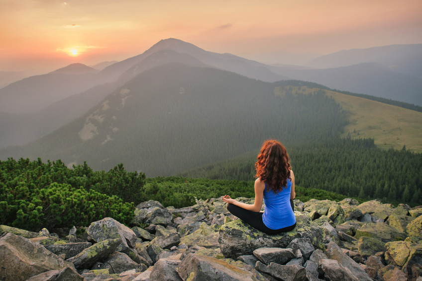 Woman feel freedom and enjoy the beautiful view in the mountains and looking on sunset
